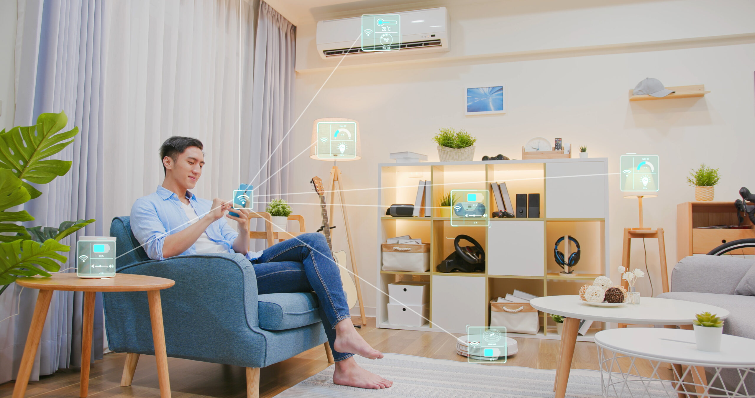 Asian,Man,Sitting,On,Sofa,And,Using,Smart,Home,Control